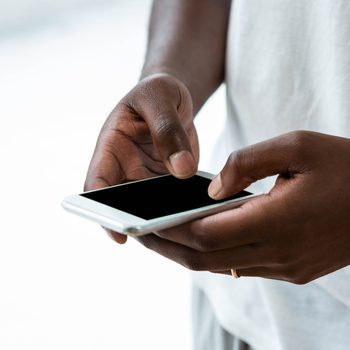 Close-up of man text messaging on mobile phone at home