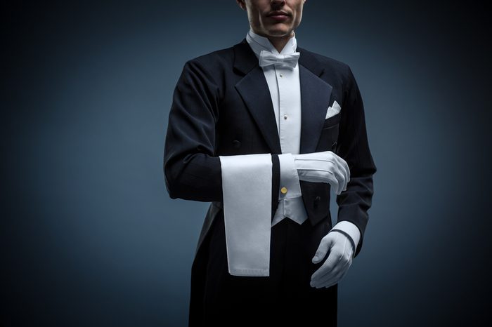 Waiter in a tuxedo on a black background