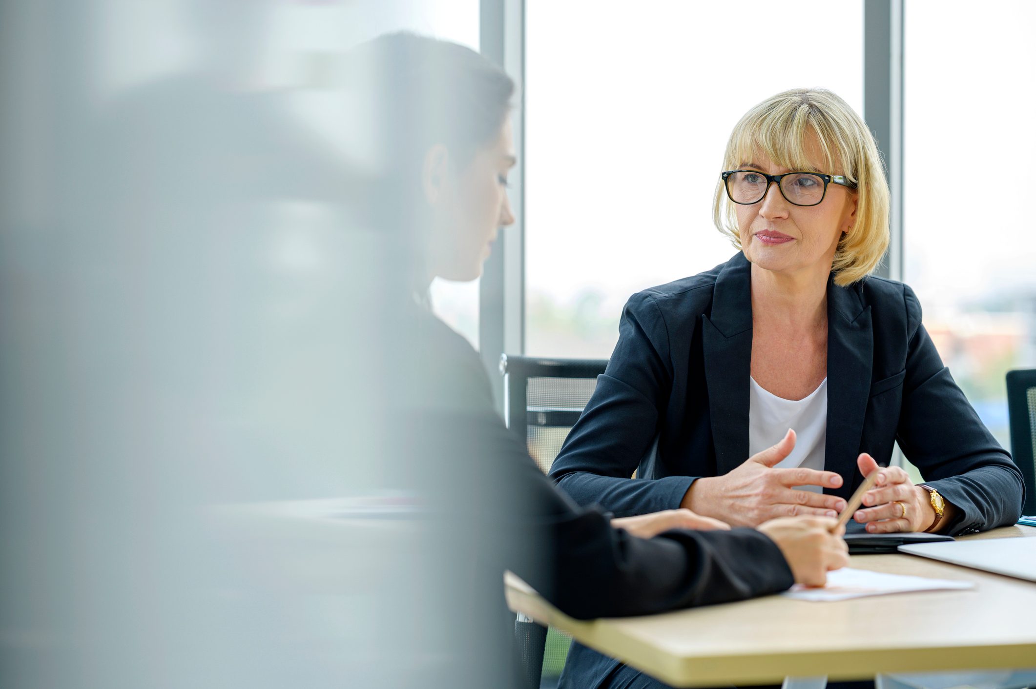Serious female financial advisor and client talking and discussing financial plan or investment plan.