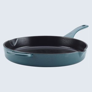 A blue cast iron skillet sits idle, featuring a long handle and helper handle, against a plain light background.