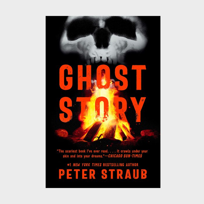 A skull looms above a campfire, creating an eerie atmosphere. Text: 