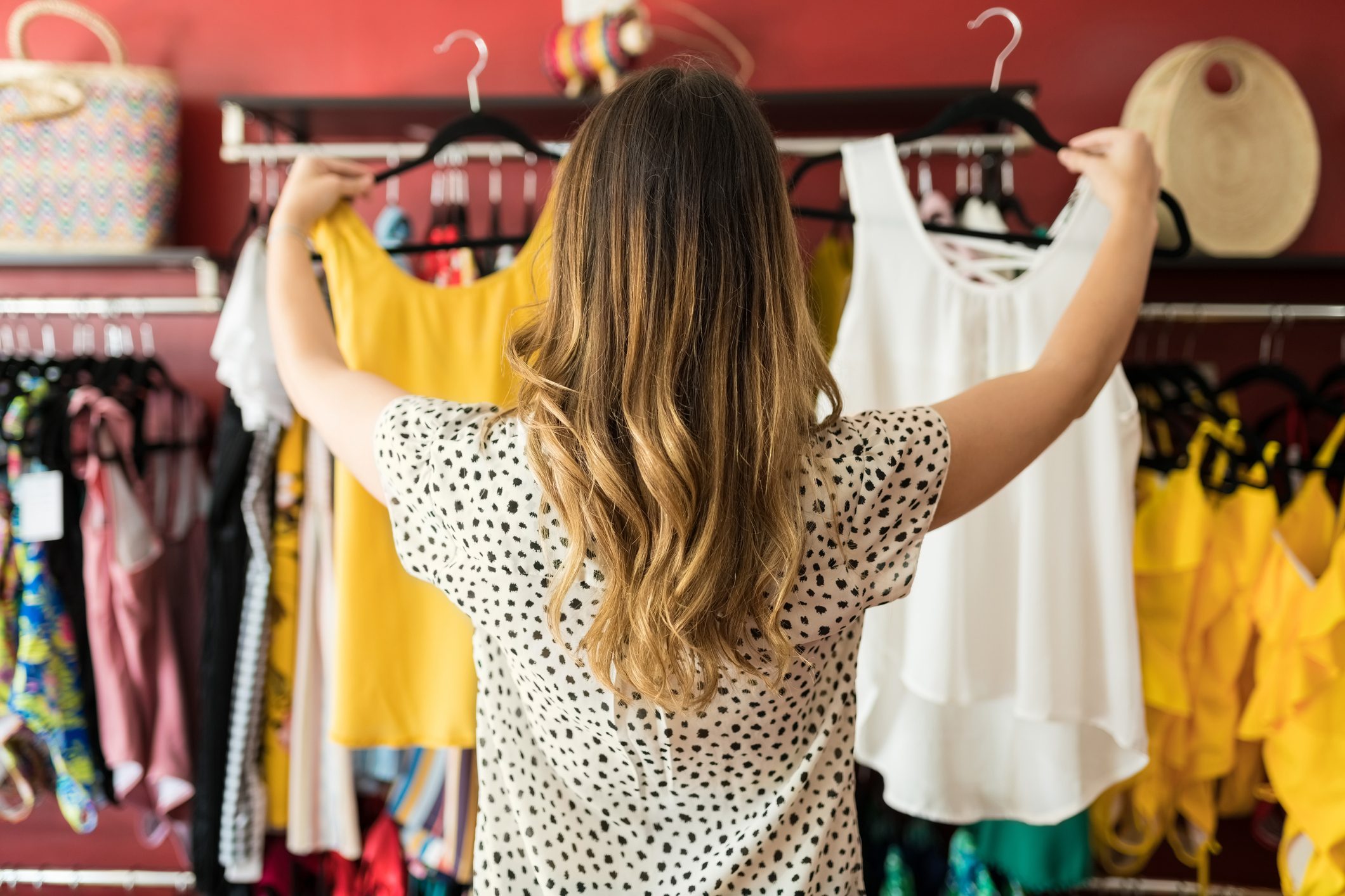 Caucasian Lady Holding At Garments In Boutique