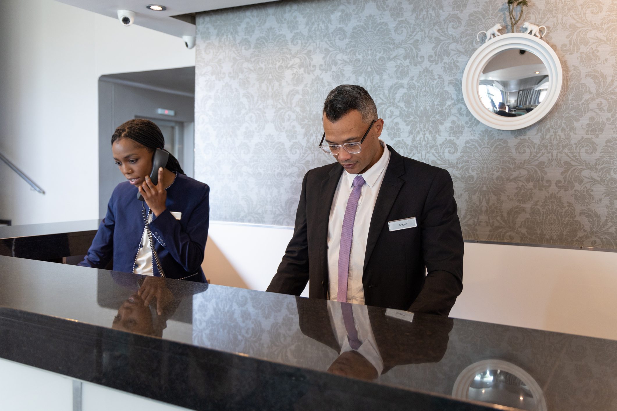 Manager and receptionist working in a busy hotel