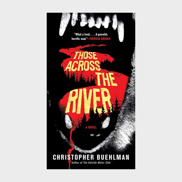 Teeth hover menacingly, framing blood-red forest silhouette with yellow text: â€œThose Across the River.â€ Dark, ominous atmosphere. Author: Christopher Buehlman.